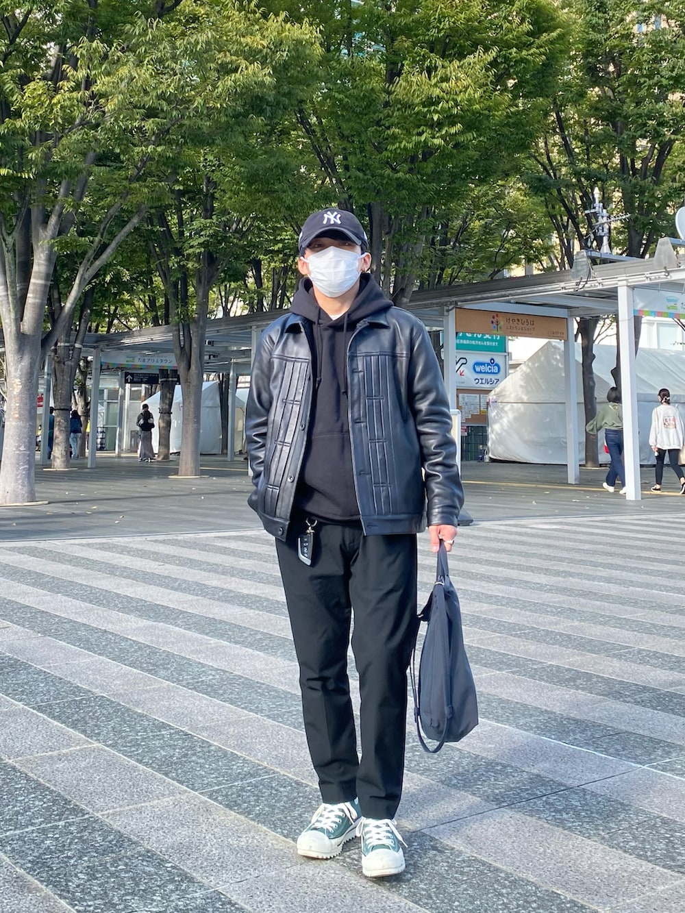 ブラック系のライダースジャケット、ブラック系のパーカー、ブラック系のスラックスを着用したメンズの秋コーディネートの3枚目の写真
