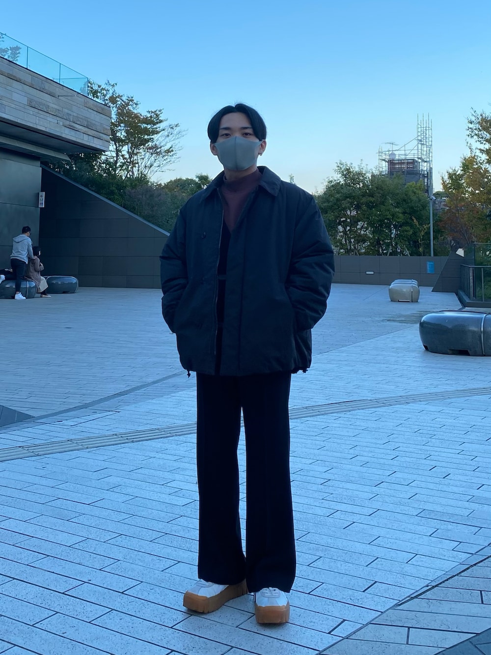 ブラック系のダウンジャケット/コート、ブラック系のカーディガン/ボレロ、レッド系のTシャツ/カットソーを着用したメンズの秋コーディネートの2枚目の写真