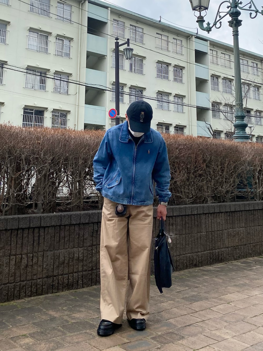 ブルー系のデニムジャケット、ベージュ系のチノパンツ、ブラック系のローファーを着用したメンズの春コーディネートの2枚目の写真