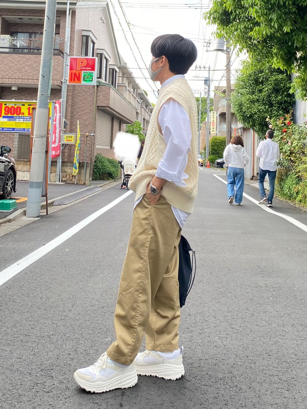 ベージュ系のニット/セーター、ホワイト系のシャツ/ブラウス、ブラック系のトートバッグを着用したメンズの春コーディネートの3枚目の写真