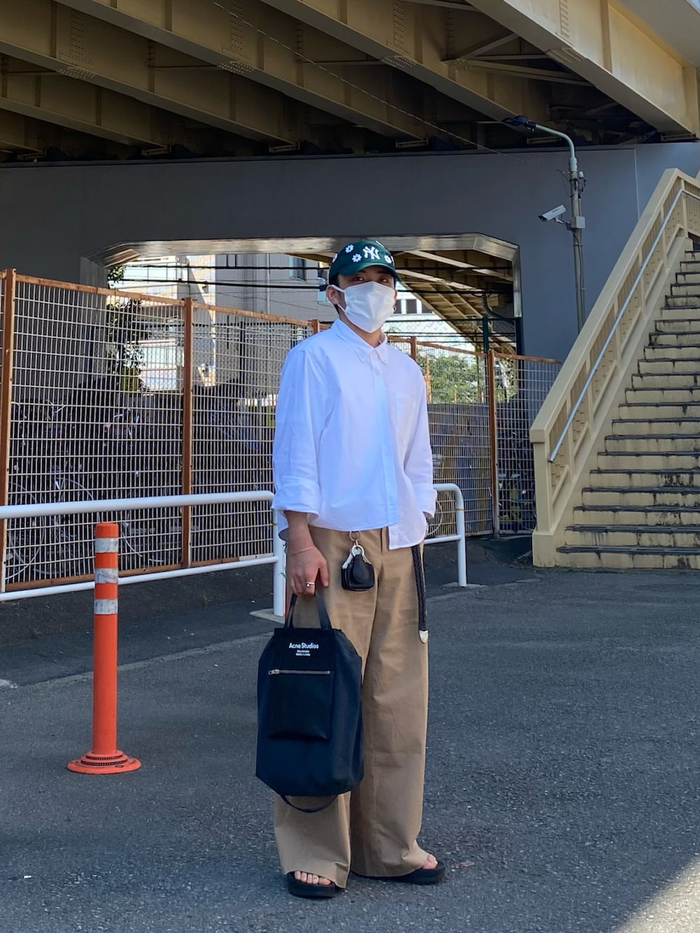 ブラック系のサンダル、ホワイト系のシャツ/ブラウス、ベージュ系のチノパンツを着用したメンズの夏コーディネートの2枚目の写真