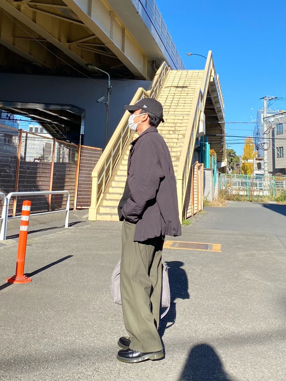 ブラック系のダウンジャケット/コート、ブラック系のベスト、ブルー系のシャツ/ブラウスを着用したメンズの冬コーディネートの4枚目の写真