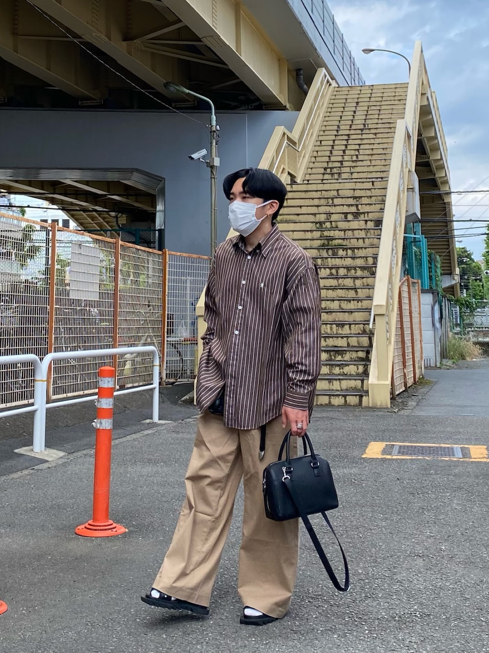 ブラウン系のシャツ/ブラウス、ベージュ系のチノパンツ、ブラック系のボストンバッグを着用したメンズの夏コーディネートの5枚目の写真