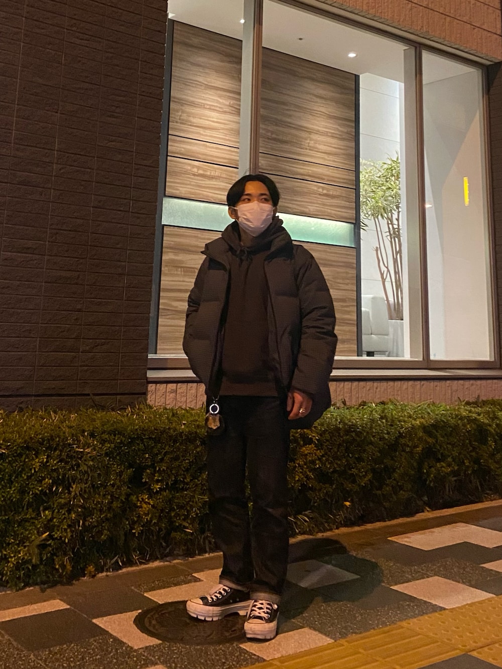 グレー系のパーカー、ブルー系のトートバッグ、グレー系のダウンジャケット/コートを着用したメンズの冬コーディネートの5枚目の写真