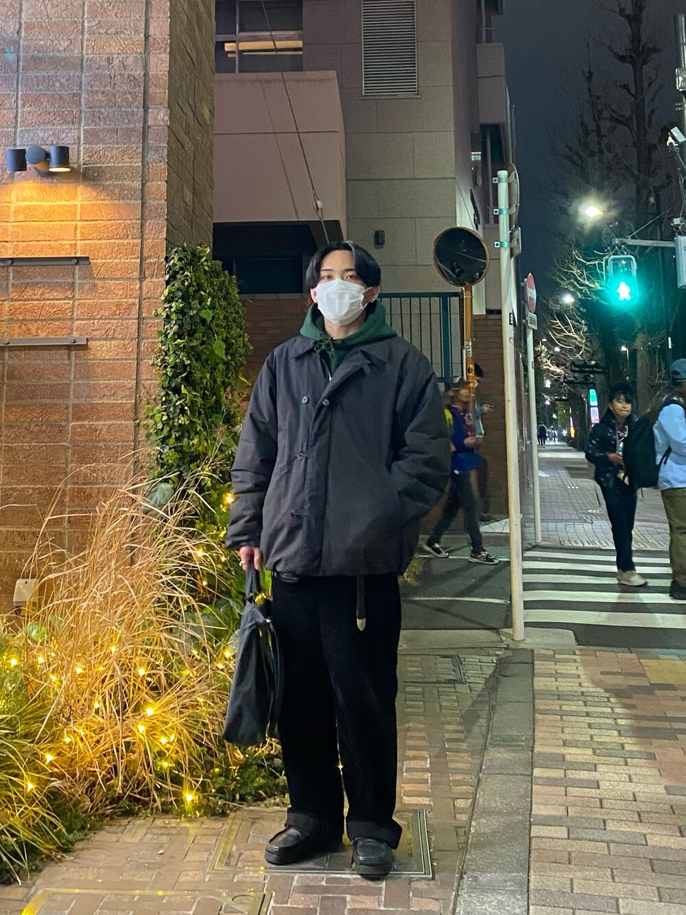 ブラック系のダウンジャケット/コート、グリーン系のパーカー、ブラック系のその他パンツを着用したメンズの冬コーディネートの5枚目の写真