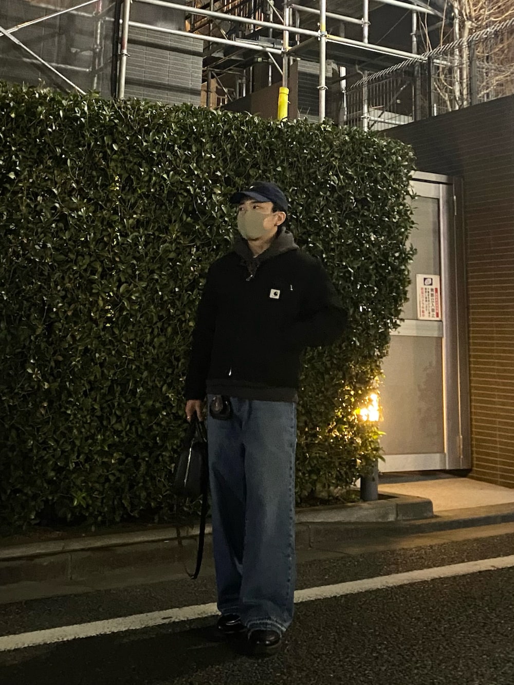 ブラック系のその他アウター、グレー系のパーカー、ブルー系のデニムパンツを着用したメンズの春コーディネートの5枚目の写真