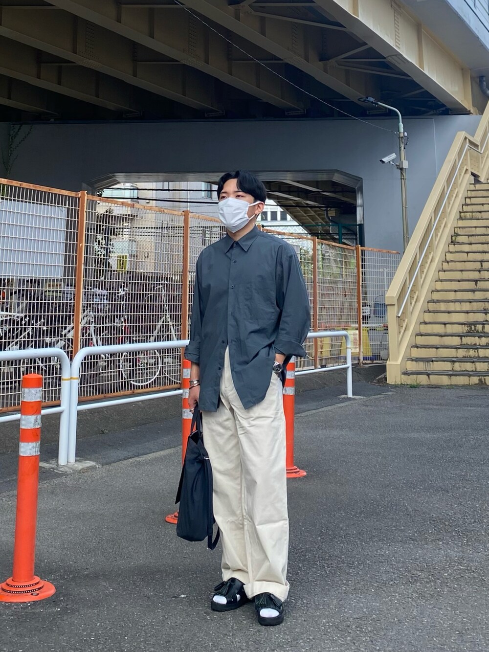 グリーン系のシャツ/ブラウス、ブラック系のトートバッグ、ホワイト系のチノパンツを着用したメンズの夏コーディネートの5枚目の写真