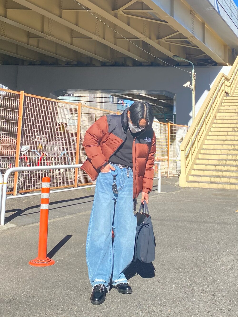 ブラウン系のダウンジャケット/コート、ブラック系のスウェット、ブルー系のデニムパンツを着用したメンズの冬コーディネートの3枚目の写真