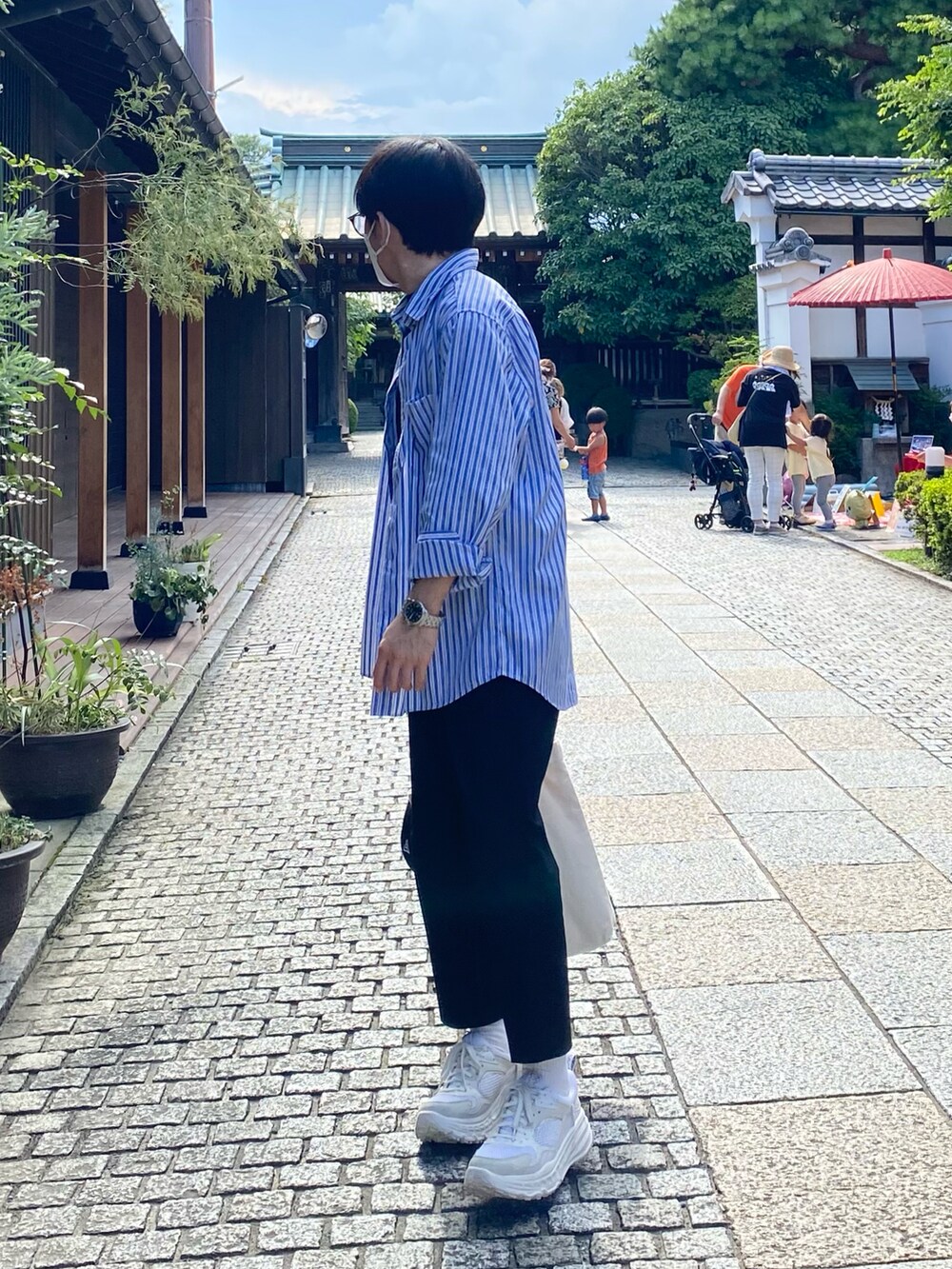 ブルー系のシャツ/ブラウス、ブラック系のTシャツ/カットソー、ブラック系のスラックスを着用したメンズの夏コーディネートの3枚目の写真
