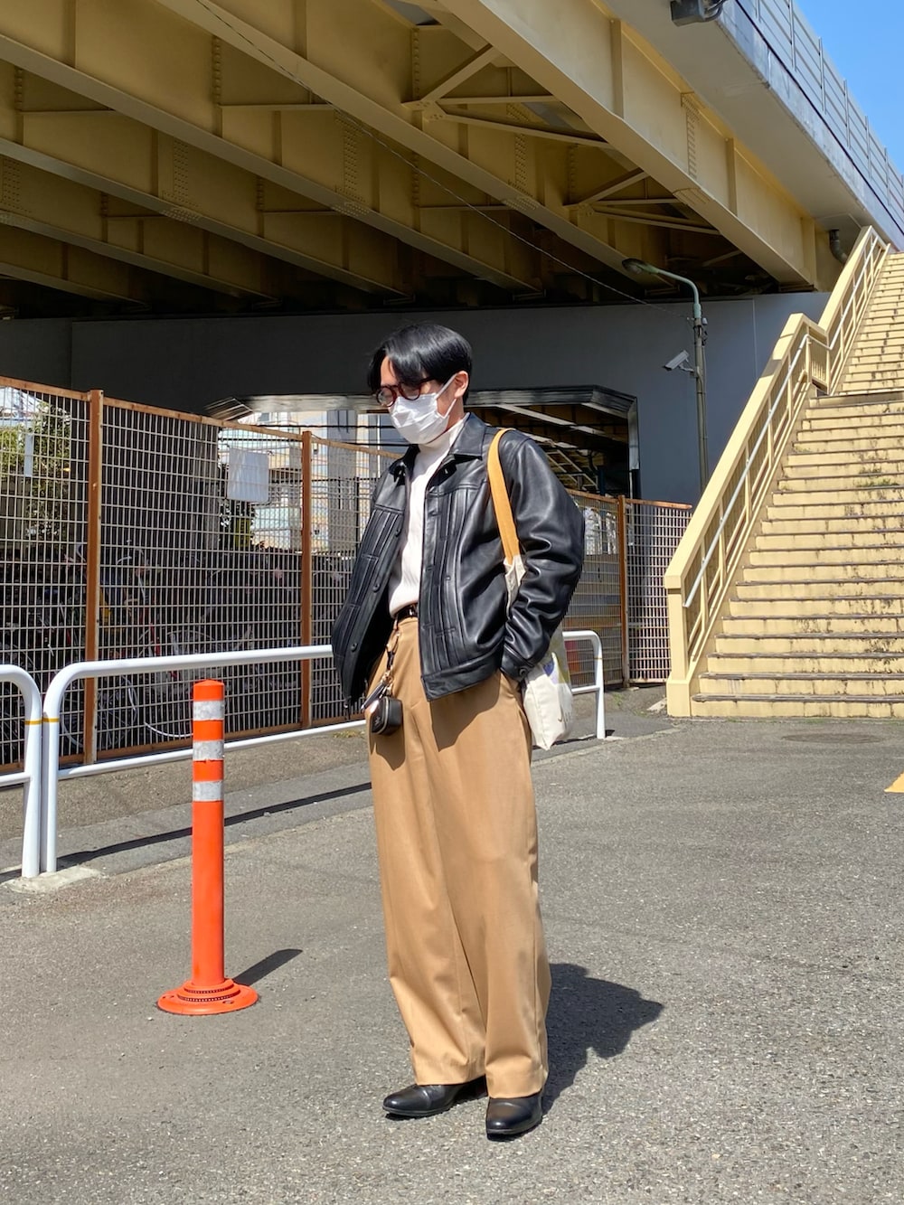 ブラック系のライダースジャケット、その他のTシャツ/カットソー、ベージュ系のスラックスを着用したメンズの春コーディネートの2枚目の写真