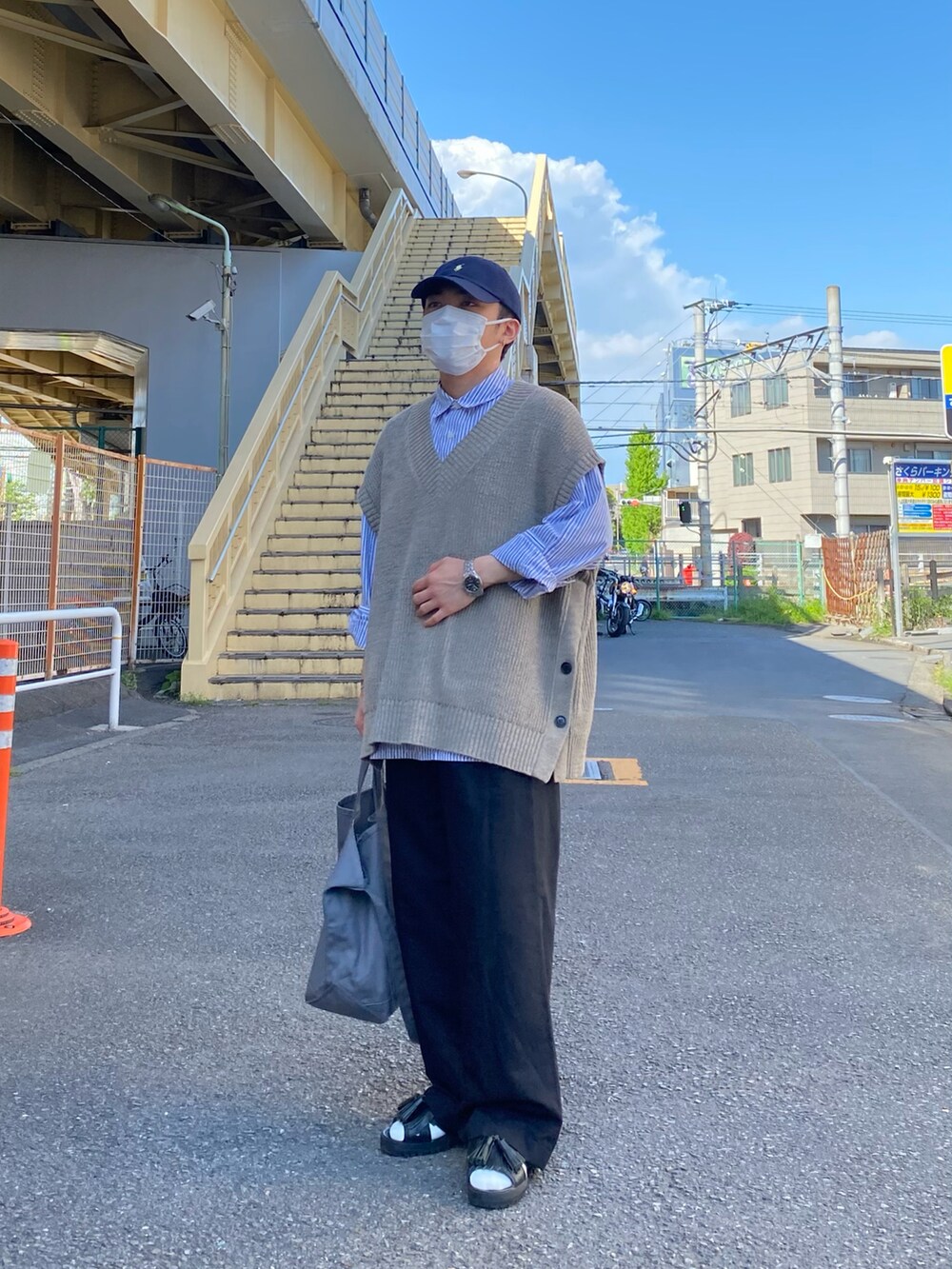 ベージュ系のベスト、ブルー系のシャツ/ブラウス、ブラック系のパンツを着用したメンズの春コーディネートの2枚目の写真