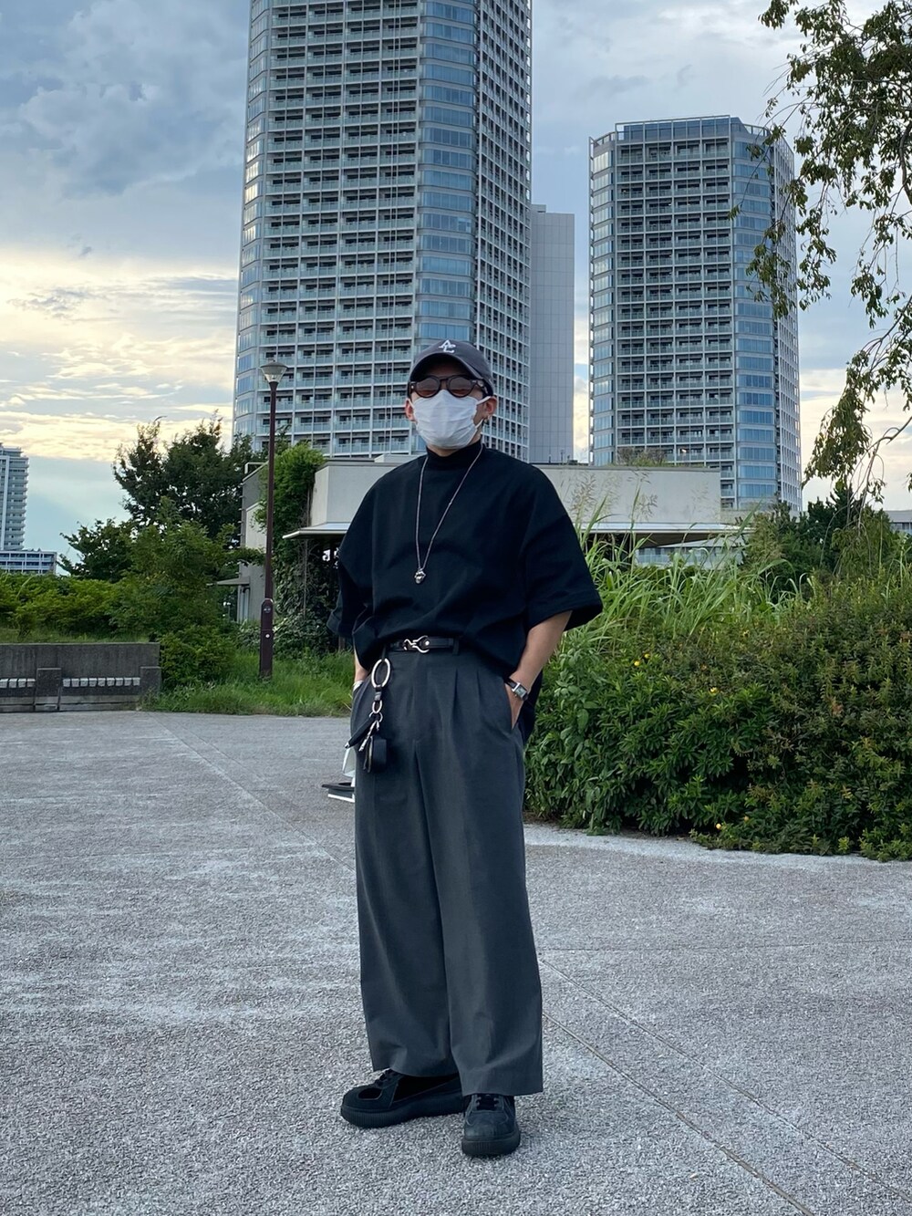 ブラック系のTシャツ/カットソー、グレー系のパンツ、ブラック系のスニーカーを着用したメンズの夏コーディネートの4枚目の写真