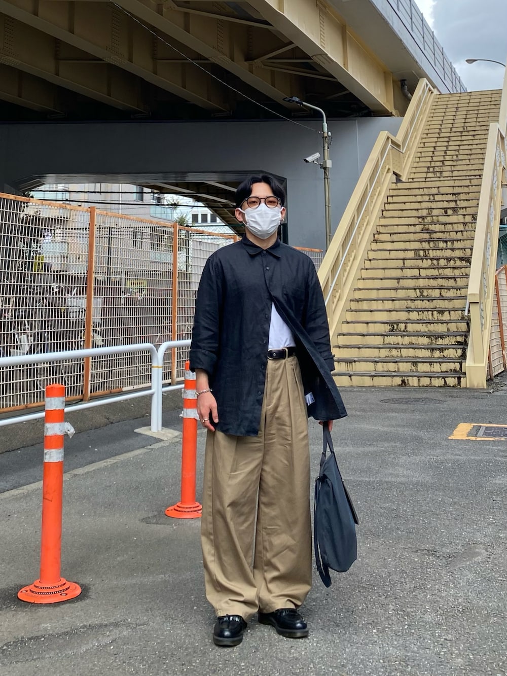 ブラック系のシャツ/ブラウス、ベージュ系のチノパンツ、ブラック系のローファーを着用したメンズの秋コーディネートの5枚目の写真