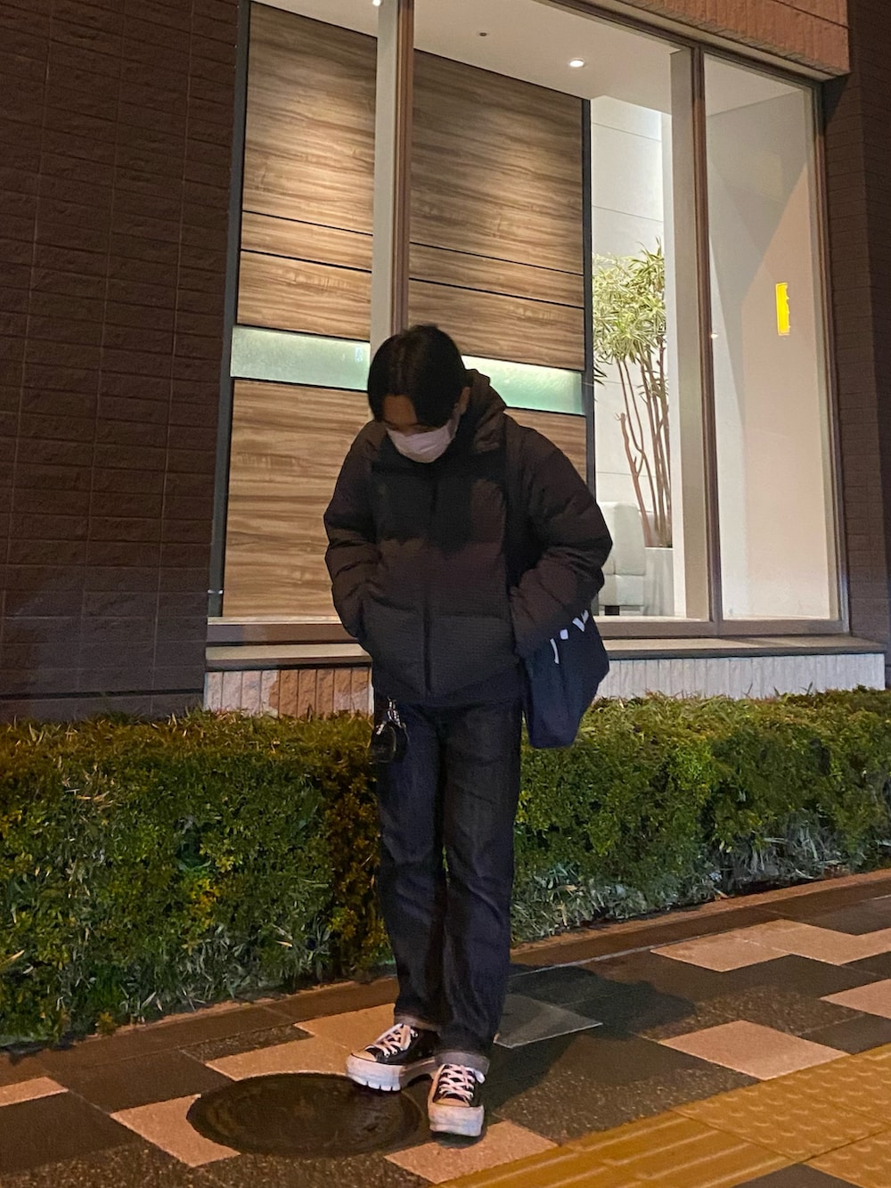 グレー系のパーカー、ブルー系のトートバッグ、グレー系のダウンジャケット/コートを着用したメンズの冬コーディネートの3枚目の写真