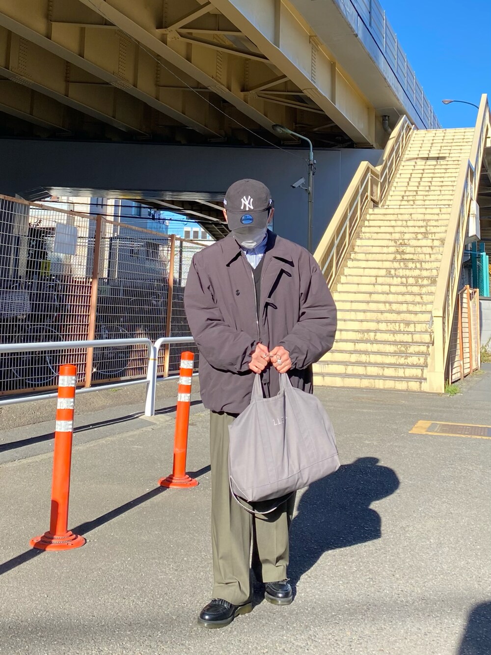 ブラック系のダウンジャケット/コート、ブラック系のベスト、ブルー系のシャツ/ブラウスを着用したメンズの冬コーディネートの2枚目の写真