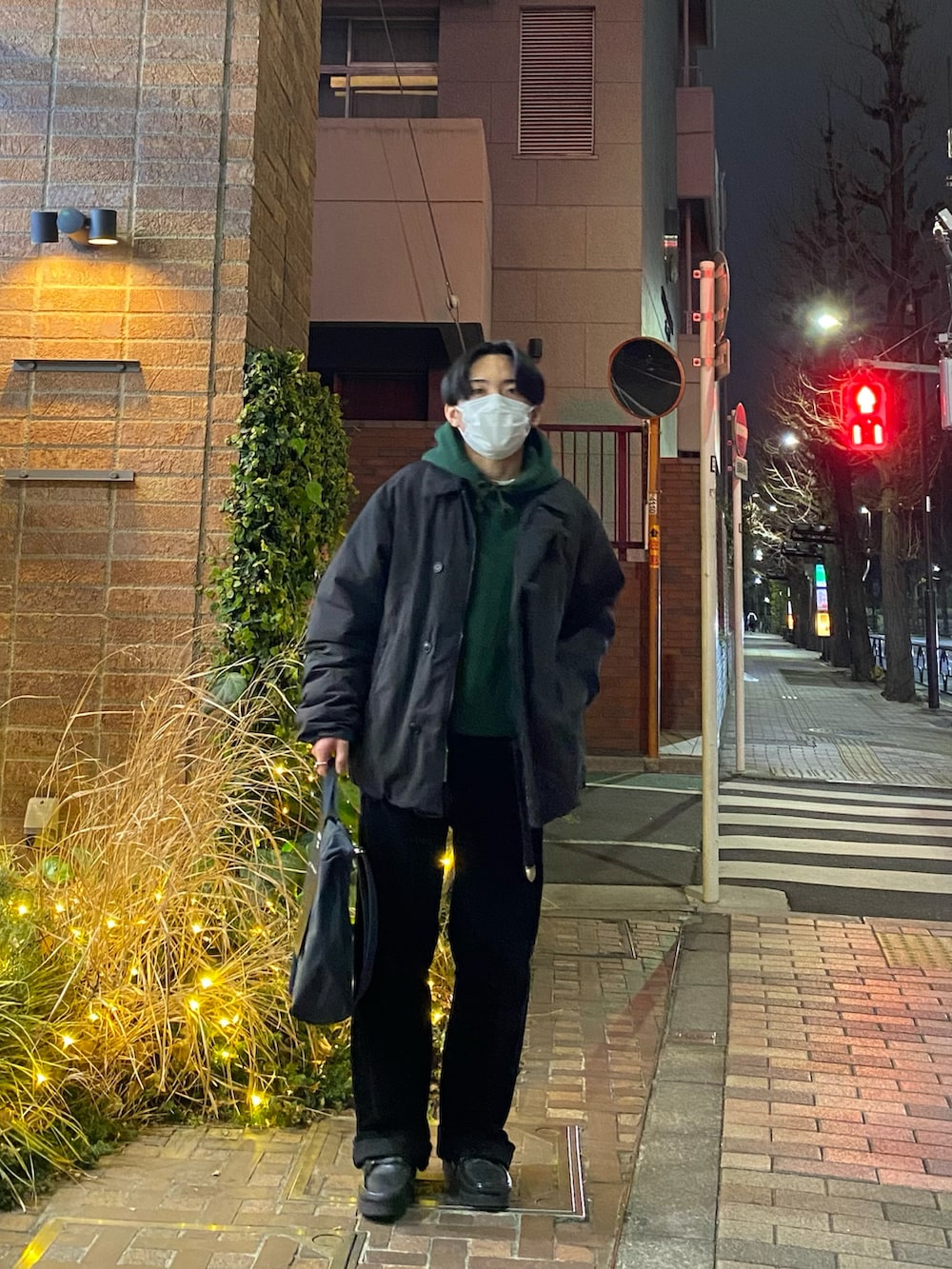 ブラック系のダウンジャケット/コート、グリーン系のパーカー、ブラック系のその他パンツを着用したメンズの冬コーディネートの2枚目の写真