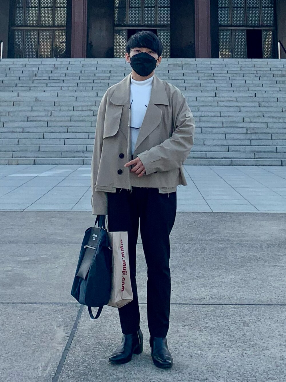 ベージュ系のブルゾン、ホワイト系のTシャツ/カットソー、ブラック系のスラックスを着用したメンズの春コーディネートの2枚目の写真