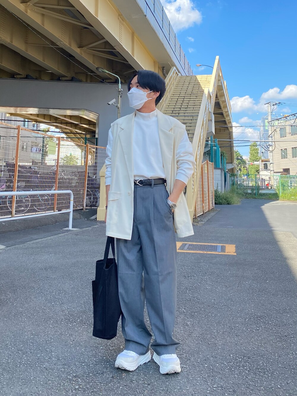 ベージュ系のベスト、グレー系のパンツ、ホワイト系のスニーカーを着用したメンズの秋コーディネートの3枚目の写真