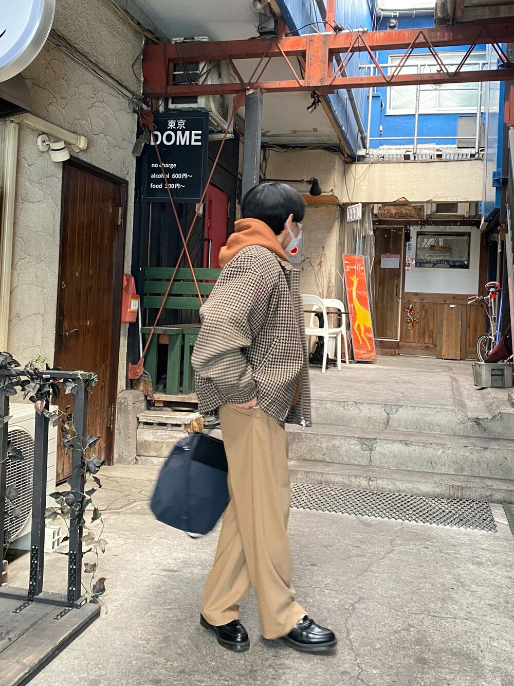 ベージュ系のブルゾン、ブラウン系のパーカー、ベージュ系のスラックスを着用したメンズの冬コーディネートの5枚目の写真