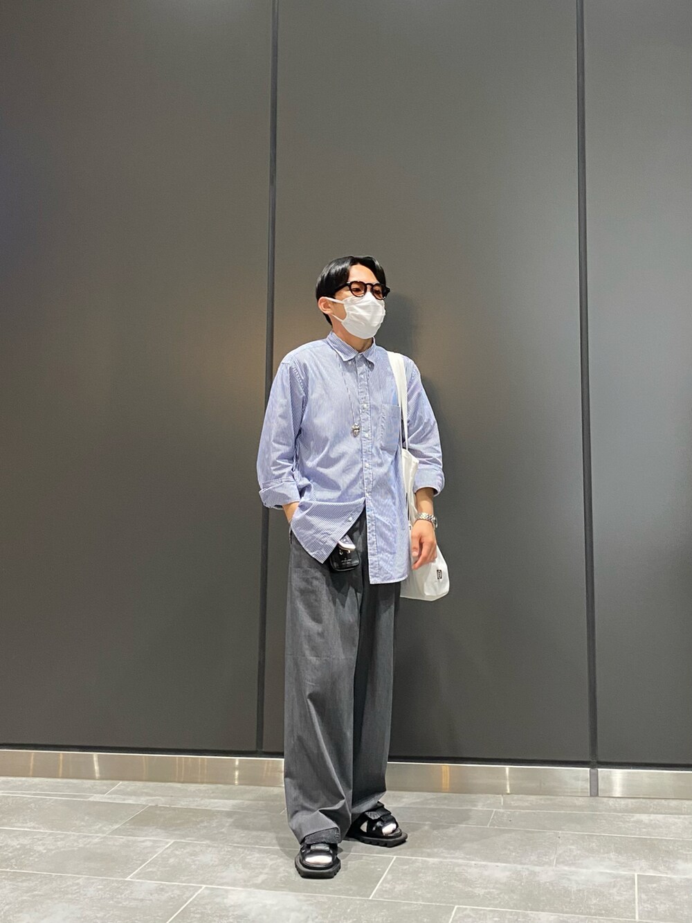 ブルー系のシャツ/ブラウス、ホワイト系のトートバッグ、ブラック系のサンダルを着用したメンズの夏コーディネートの5枚目の写真