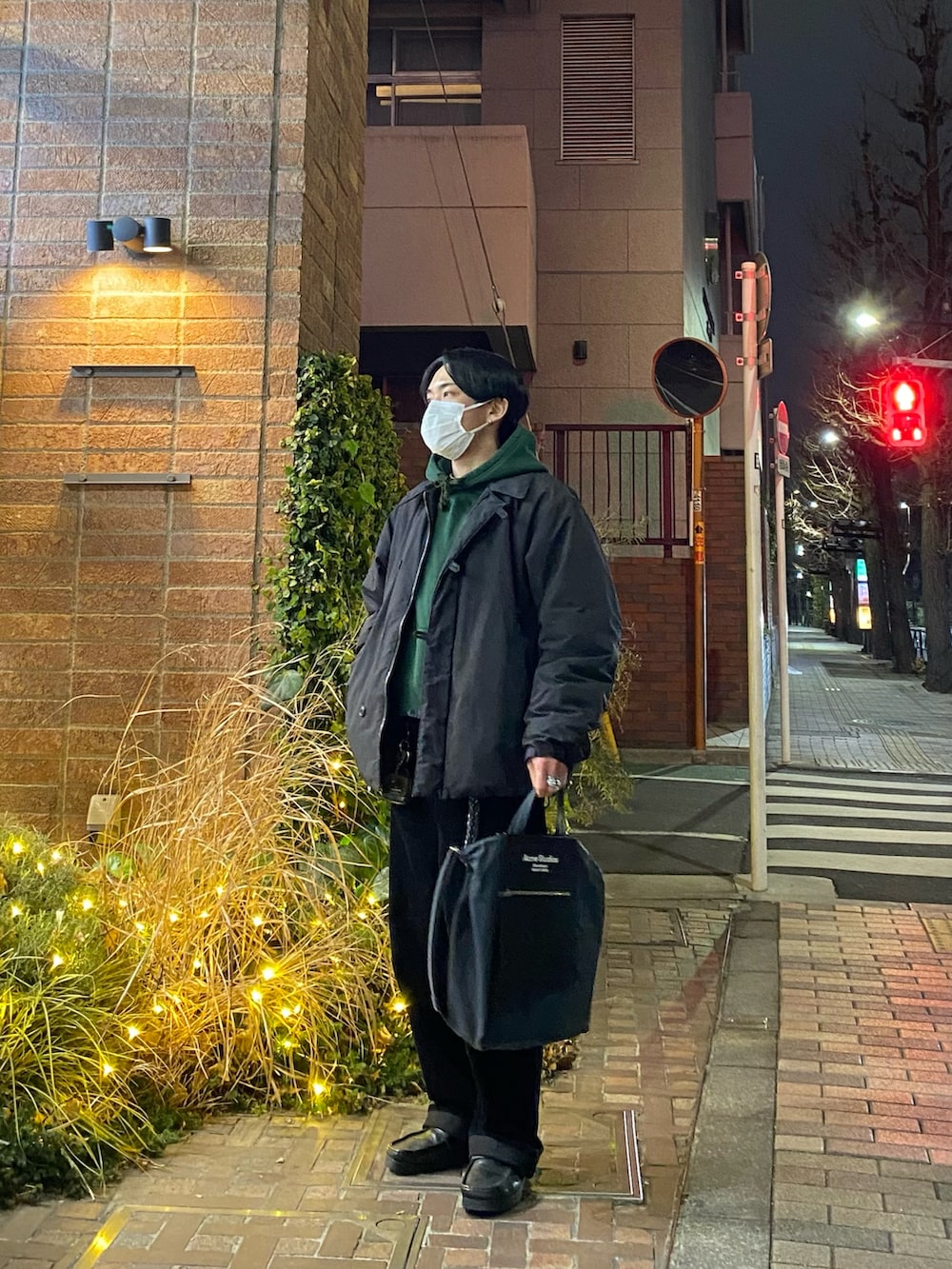 ブラック系のダウンジャケット/コート、グリーン系のパーカー、ブラック系のその他パンツを着用したメンズの冬コーディネートの3枚目の写真