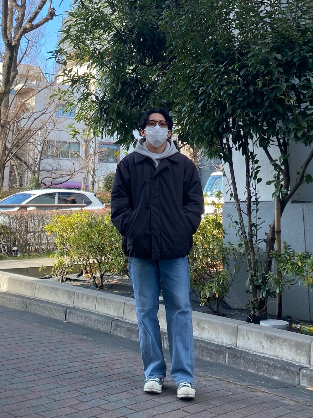 ブラック系のダウンジャケット/コート、グレー系のパーカー、ブルー系のデニムパンツを着用したメンズの冬コーディネートの4枚目の写真