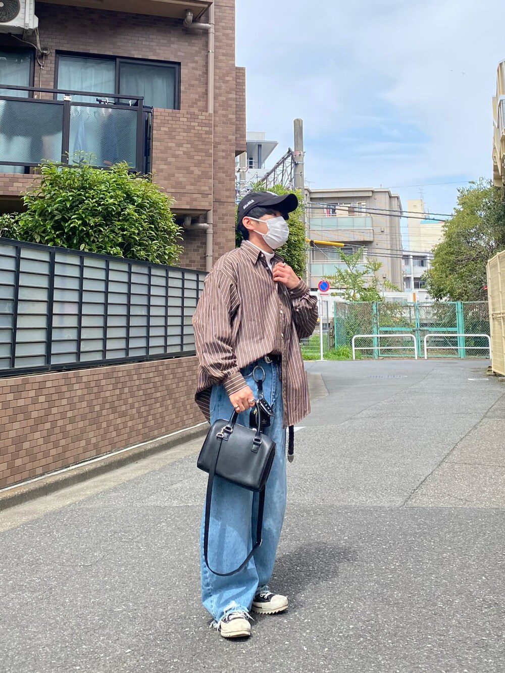 ブラウン系のシャツ/ブラウス、ホワイト系のTシャツ/カットソー、ブルー系のデニムパンツを着用したメンズの春コーディネートの3枚目の写真