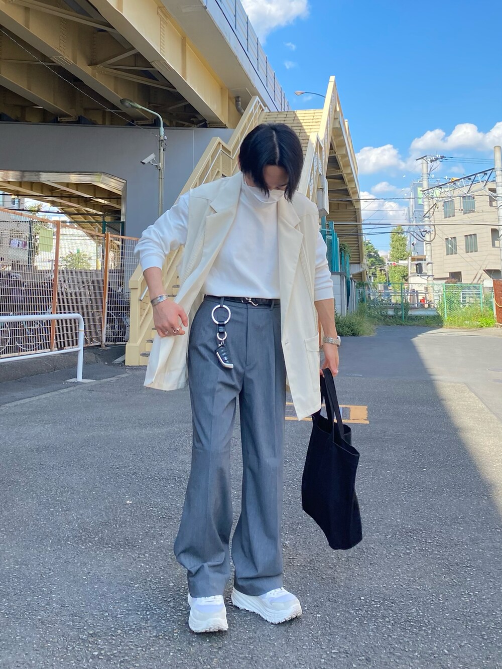 ベージュ系のベスト、グレー系のパンツ、ホワイト系のスニーカーを着用したメンズの秋コーディネートの2枚目の写真