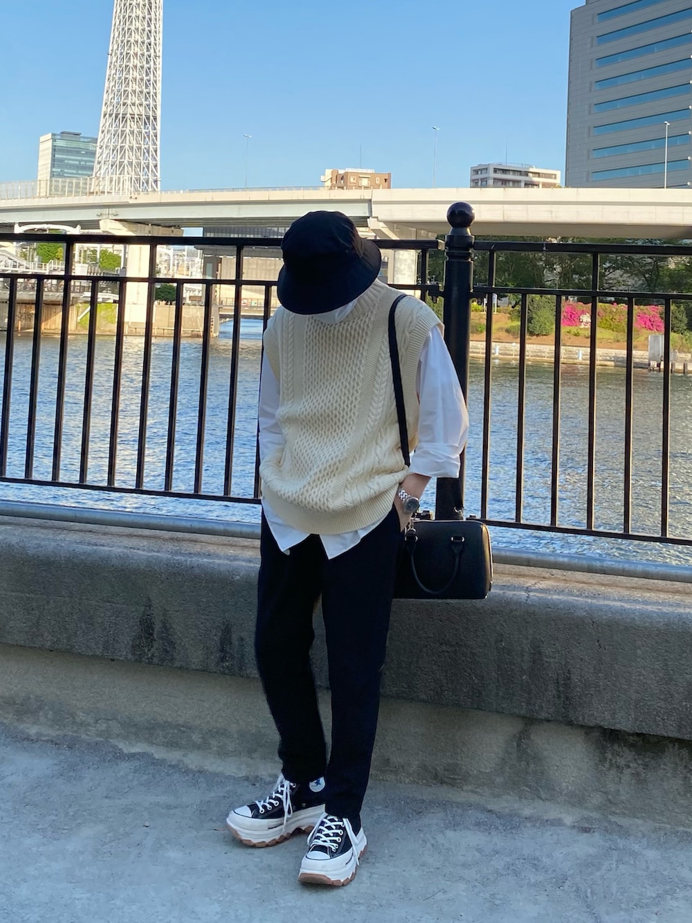 ベージュ系のニット/セーター、ホワイト系のシャツ/ブラウス、ブラック系のスラックスを着用したメンズの春コーディネートの2枚目の写真