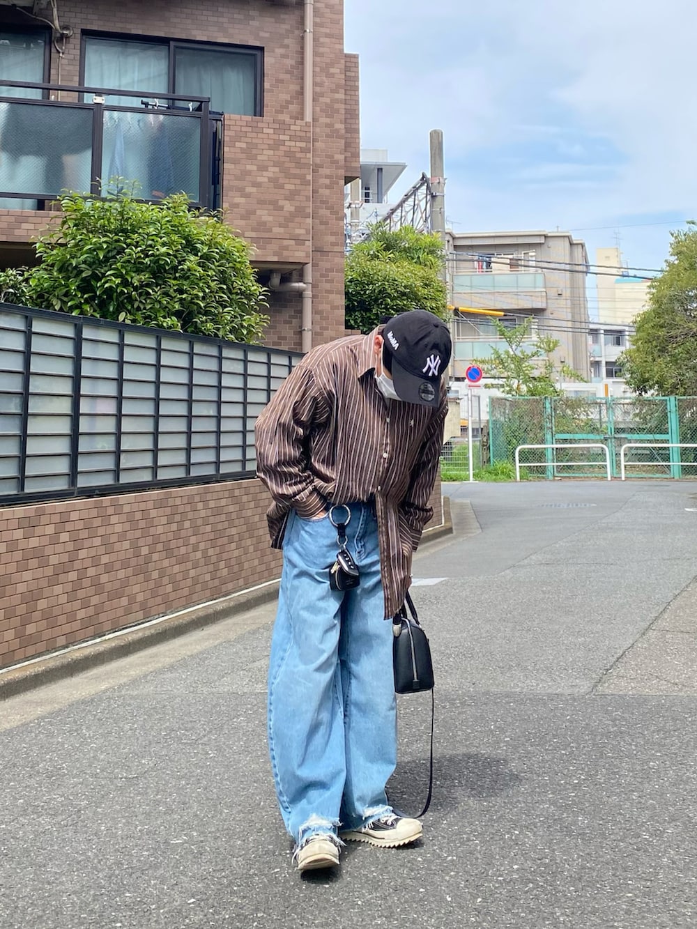 ブラウン系のシャツ/ブラウス、ホワイト系のTシャツ/カットソー、ブルー系のデニムパンツを着用したメンズの春コーディネートの2枚目の写真