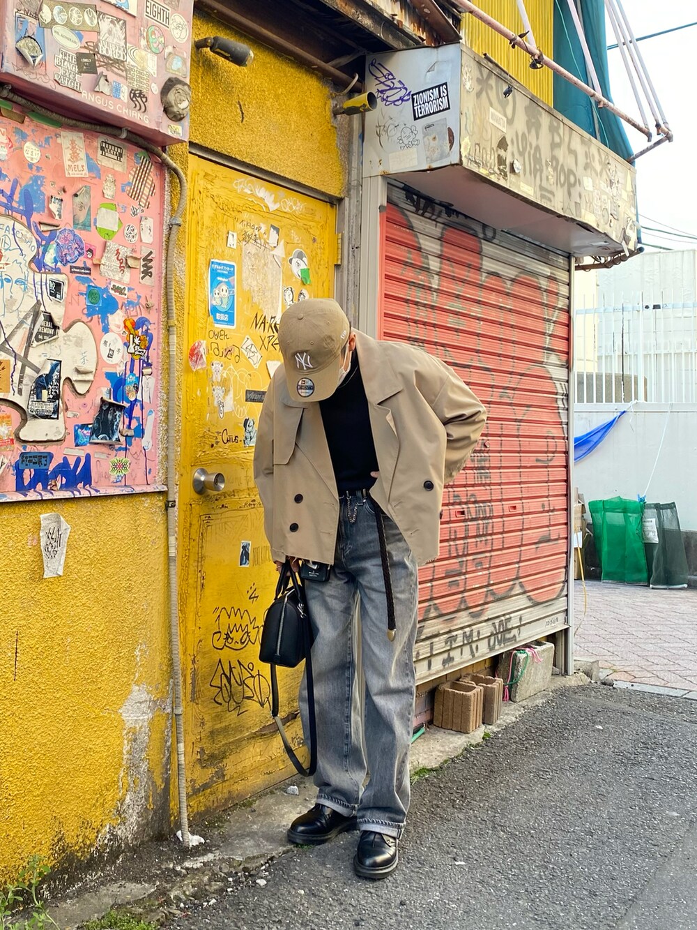 ベージュ系のブルゾン、ブラック系のスウェット、グレー系のデニムパンツを着用したメンズの春コーディネートの5枚目の写真