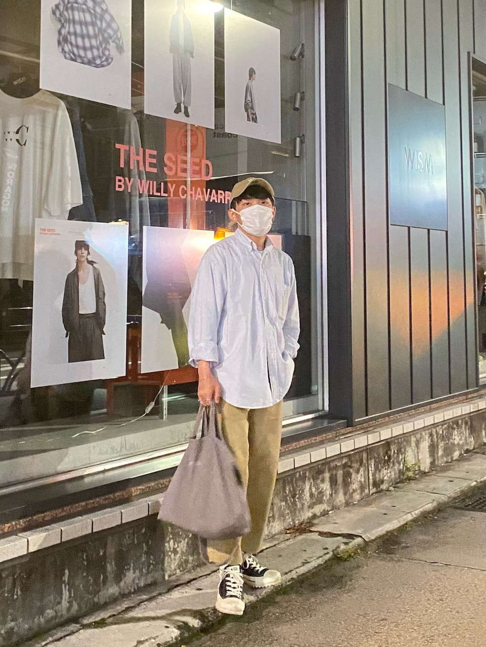 ブルー系のシャツ/ブラウス、ベージュ系のチノパンツ、ブラック系のスニーカーを着用したメンズの夏コーディネートの2枚目の写真