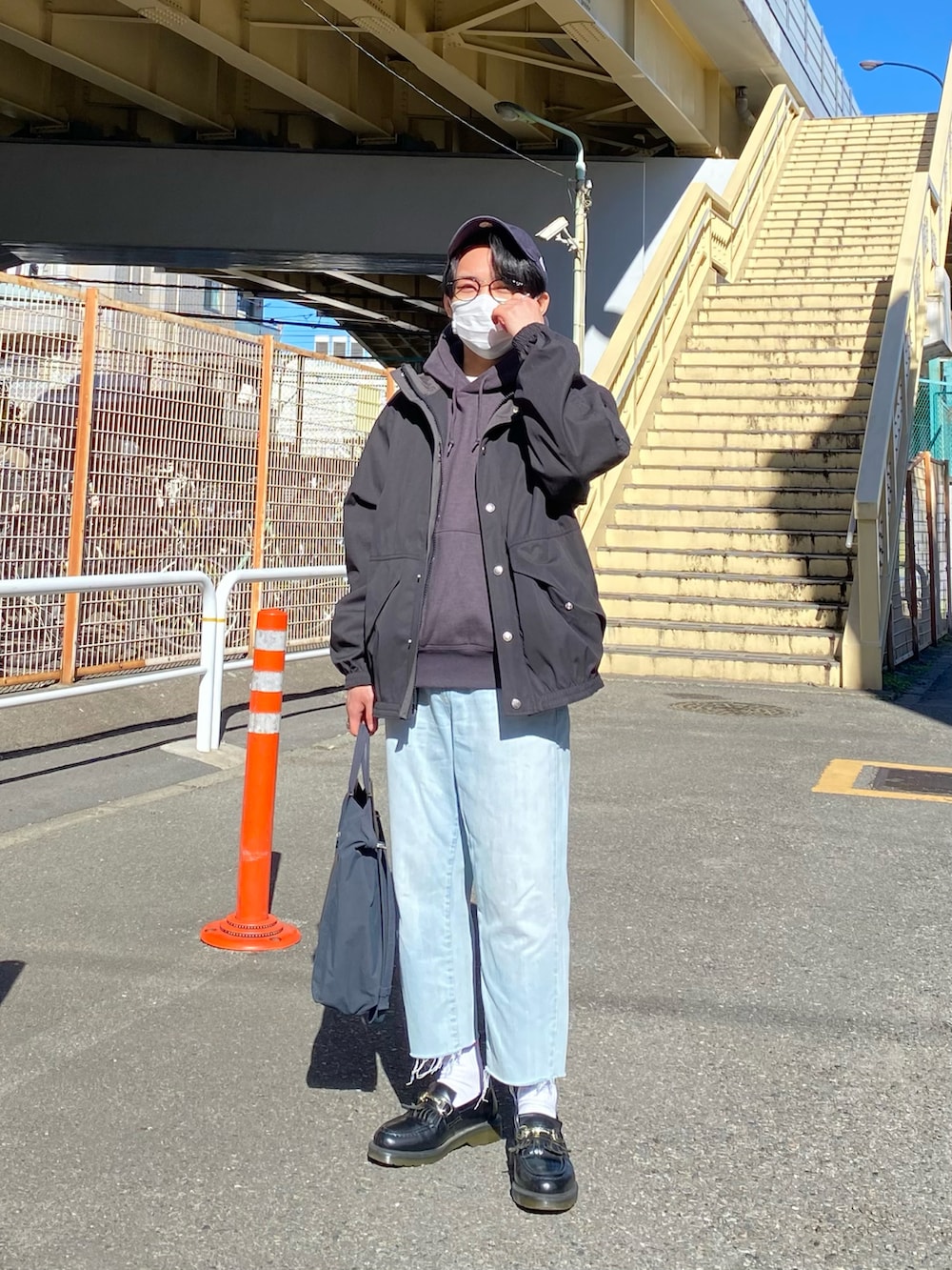 ブラック系のブルゾン、グレー系のパーカー、ブルー系のデニムパンツを着用したメンズの冬コーディネートの5枚目の写真