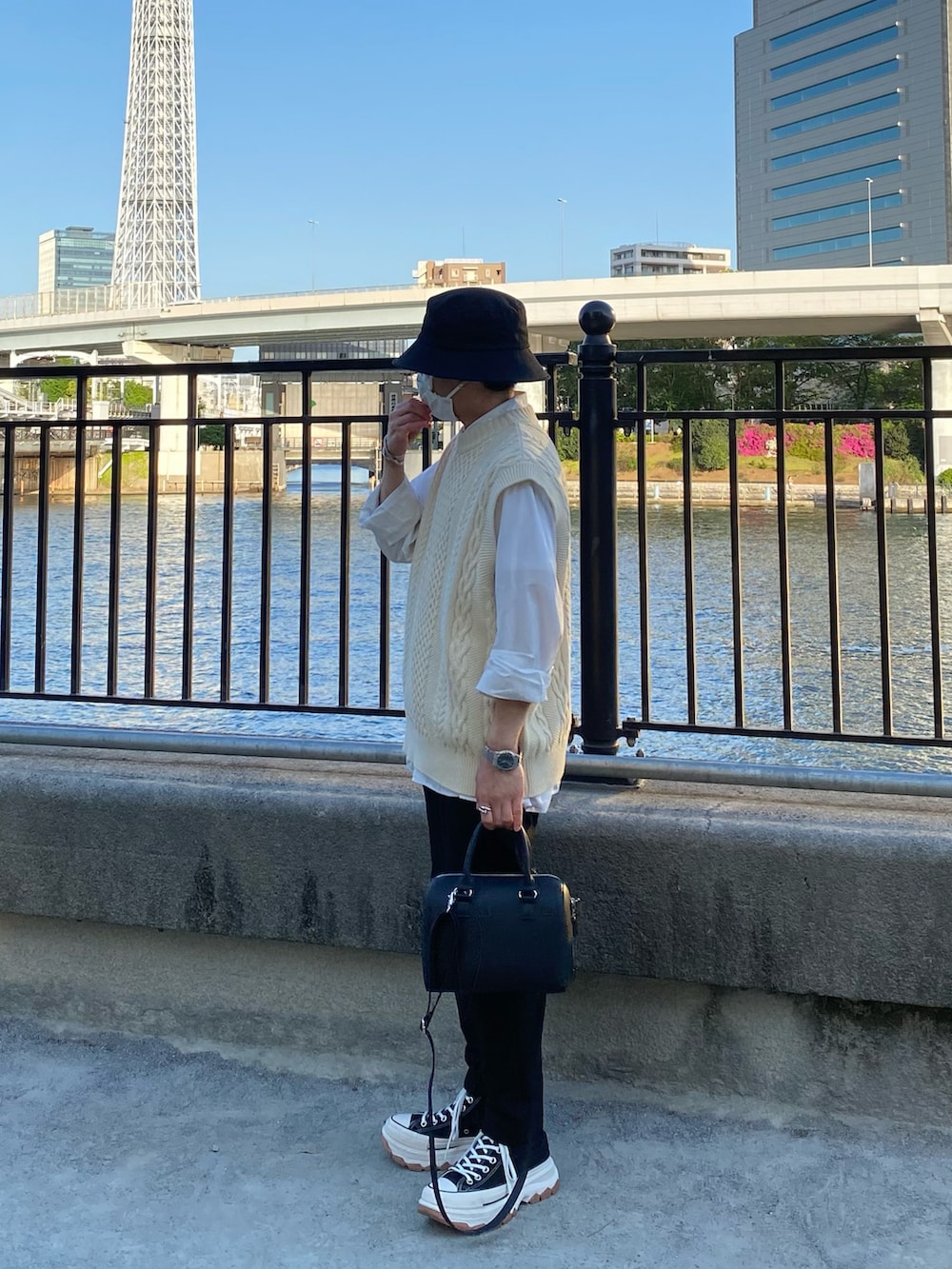 ベージュ系のニット/セーター、ホワイト系のシャツ/ブラウス、ブラック系のスラックスを着用したメンズの春コーディネートの3枚目の写真