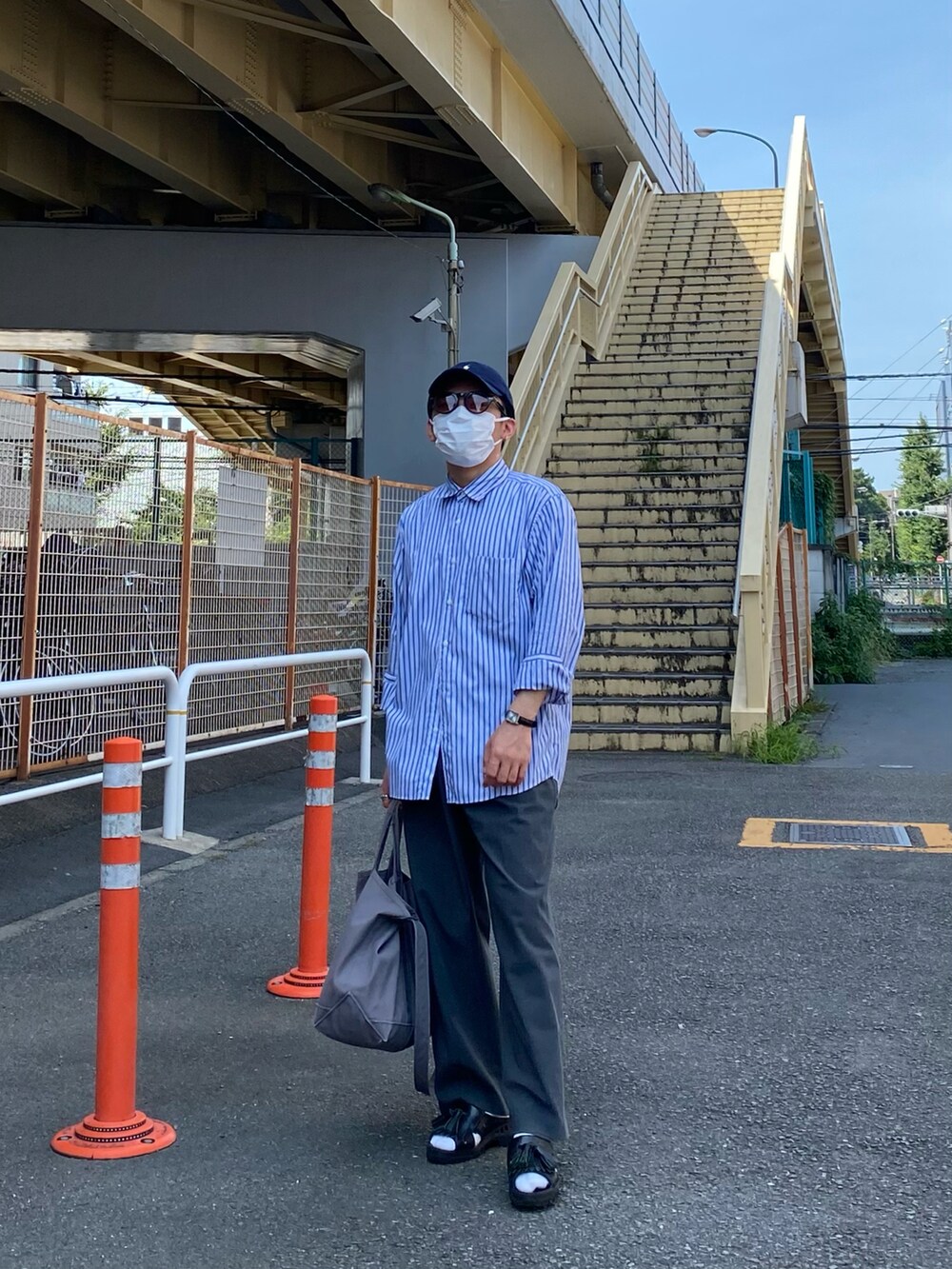 ブルー系のシャツ/ブラウス、グレー系のパンツ、ブラック系のサンダルを着用したメンズの夏コーディネートの2枚目の写真