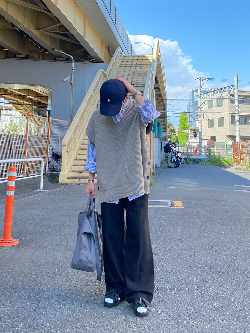 ベージュ系のベスト、ブルー系のシャツ/ブラウス、ブラック系のパンツを着用したメンズの春コーディネートの4枚目の写真