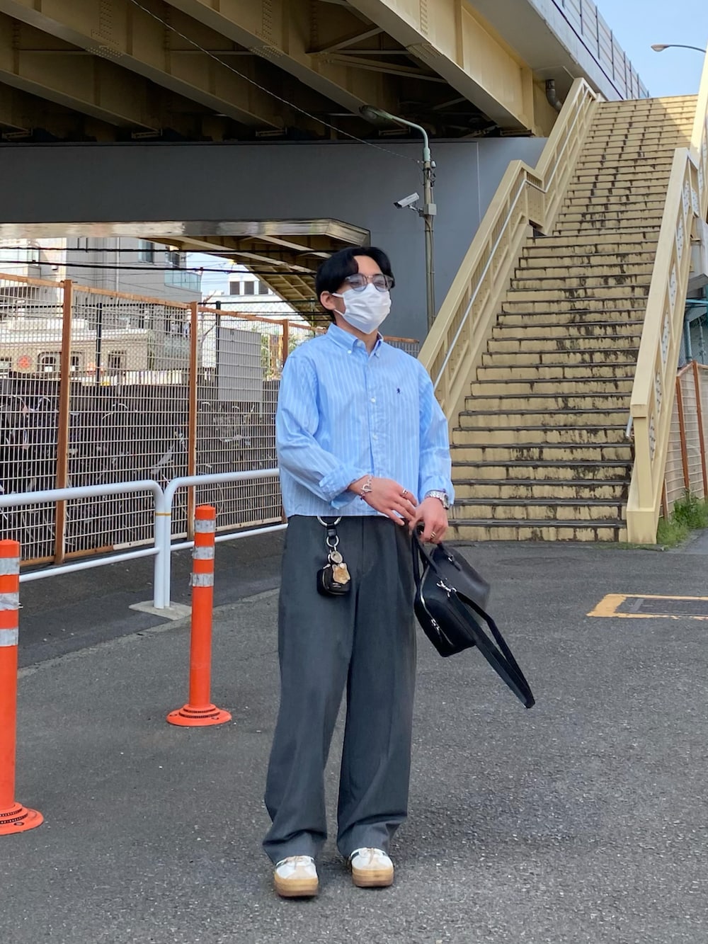 ブルー系のシャツ/ブラウス、ブラック系のボストンバッグ、グレー系のパンツを着用したメンズの春コーディネートの2枚目の写真