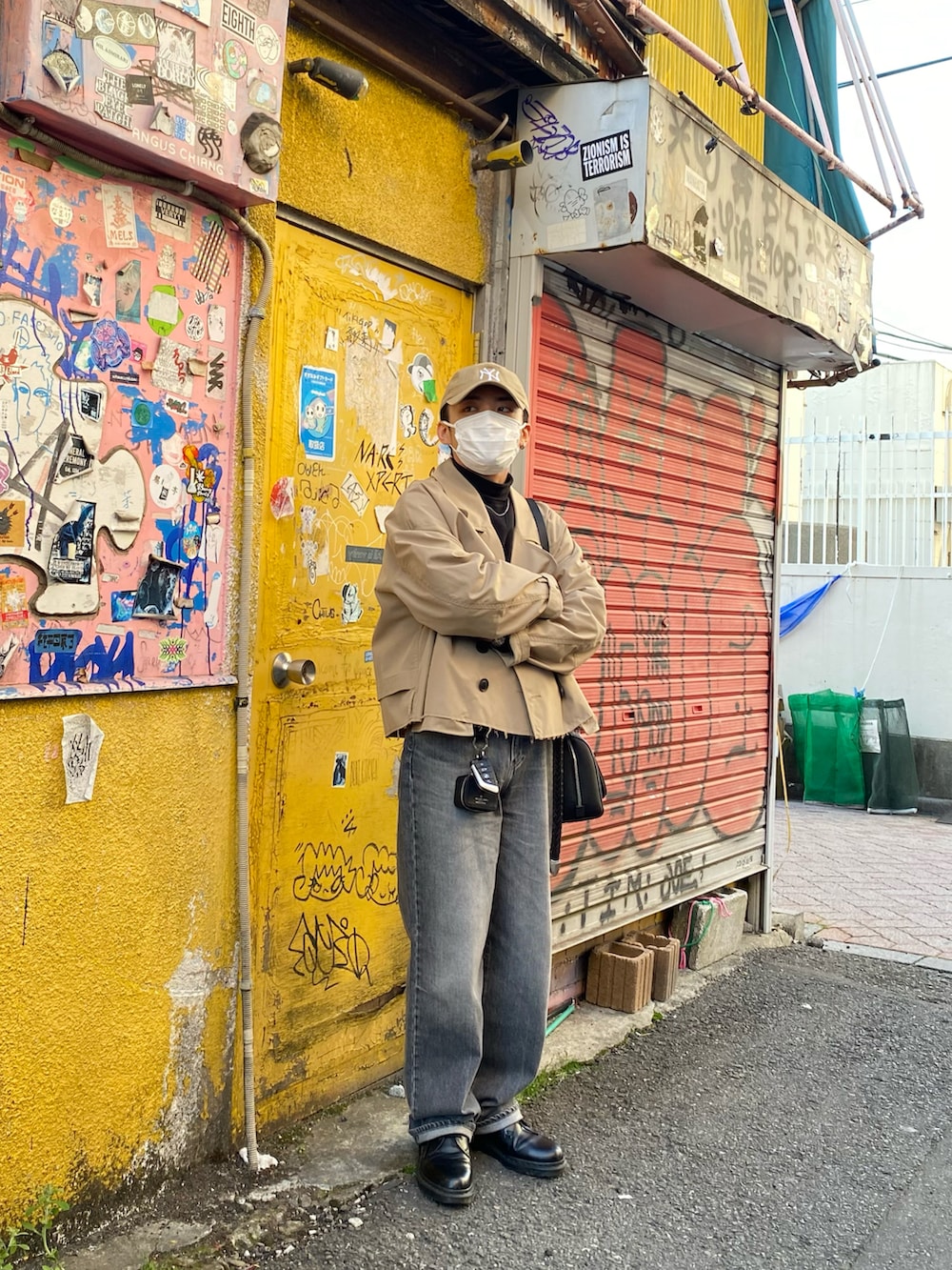 ベージュ系のブルゾン、ブラック系のスウェット、グレー系のデニムパンツを着用したメンズの春コーディネートの3枚目の写真