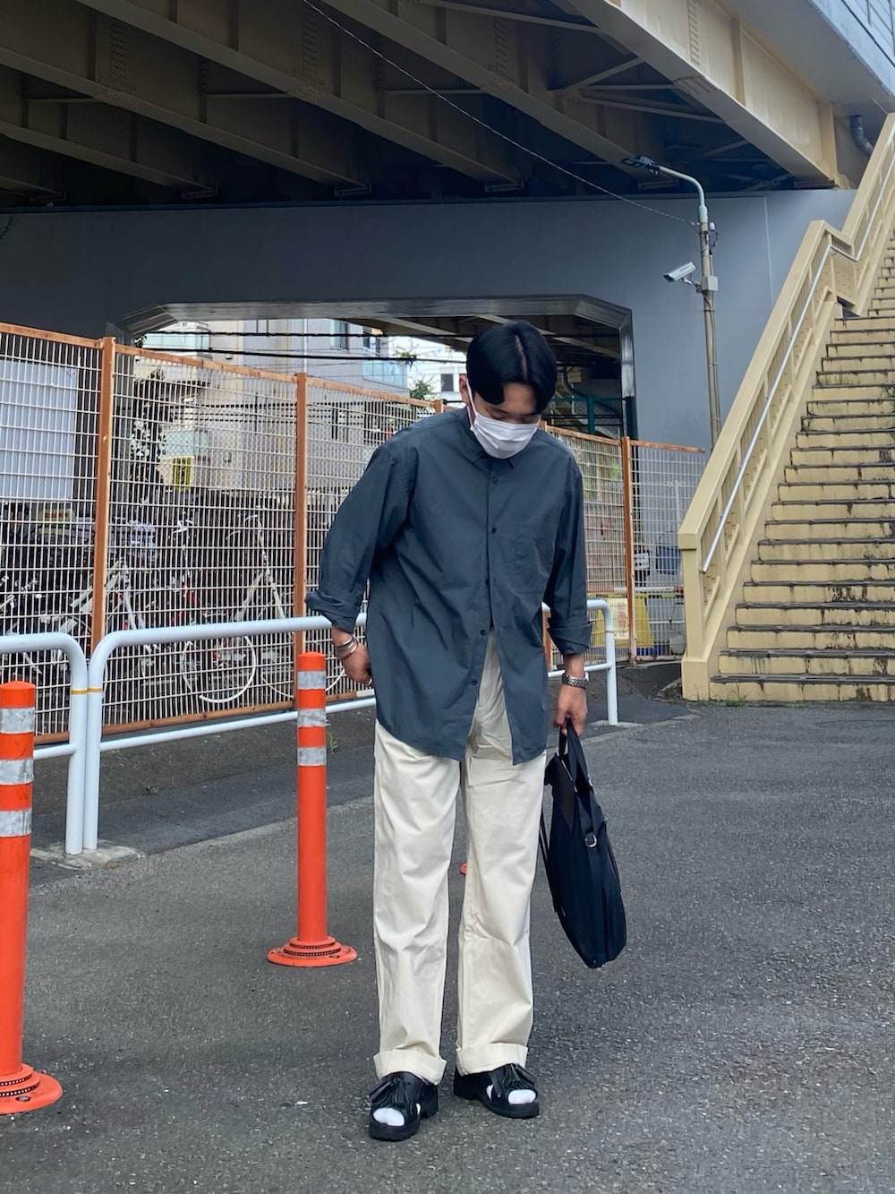 グリーン系のシャツ/ブラウス、ブラック系のトートバッグ、ホワイト系のチノパンツを着用したメンズの夏コーディネートの2枚目の写真