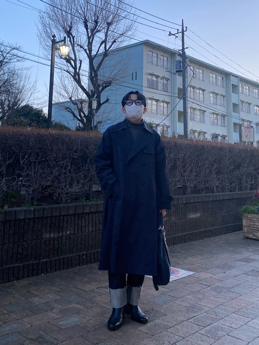 ブラック系のスウェット、ブルー系のデニムパンツ、ブラック系のブーツを着用したメンズの春コーディネートの4枚目の写真