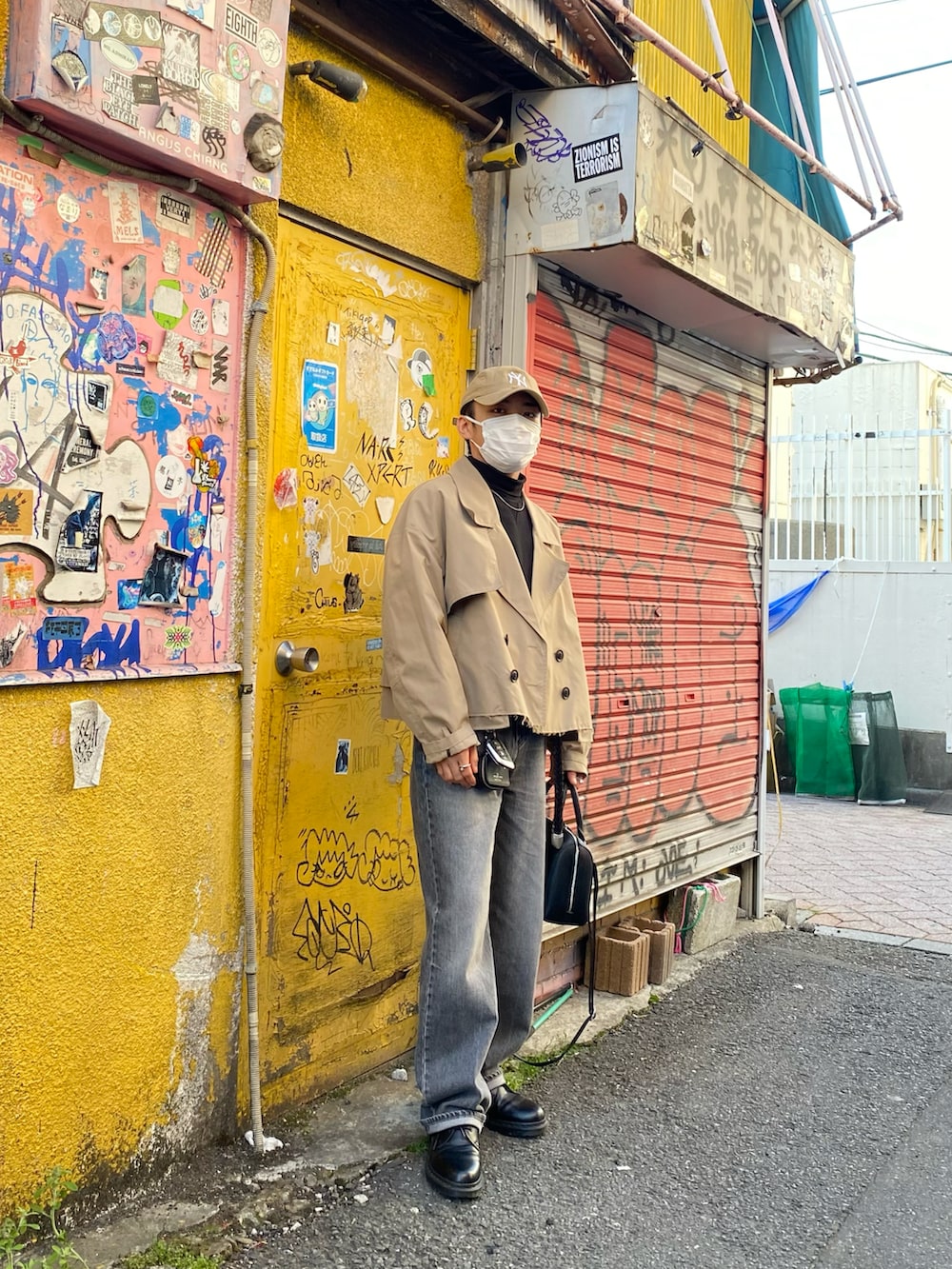 ベージュ系のブルゾン、ブラック系のスウェット、グレー系のデニムパンツを着用したメンズの春コーディネートの2枚目の写真