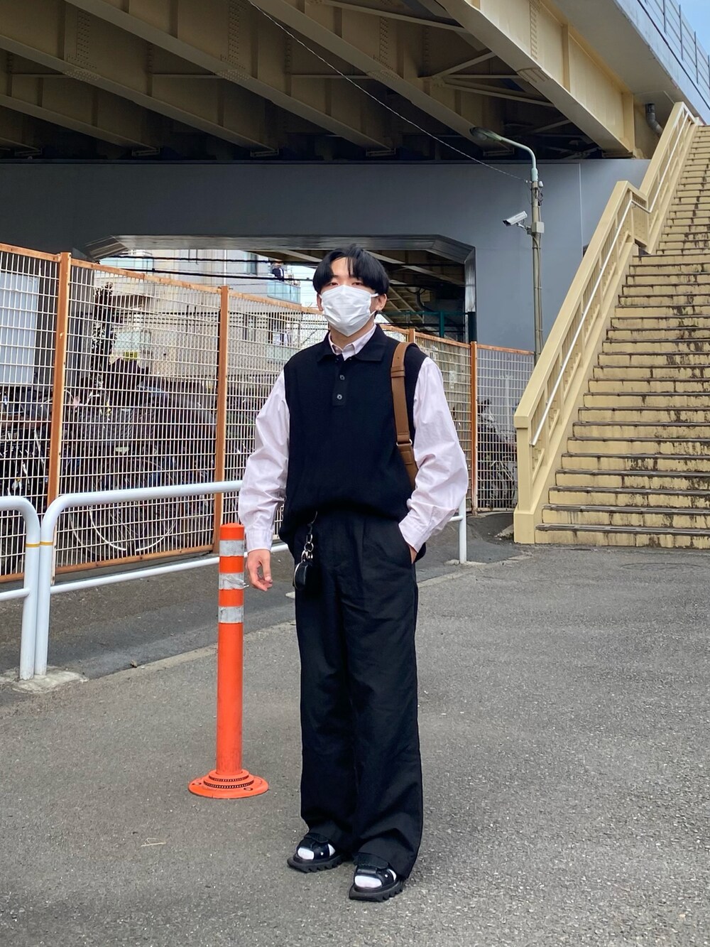 ブラック系のベスト、ピンク系のシャツ/ブラウス、ブラウン系のバッグを着用したメンズの春コーディネートの3枚目の写真