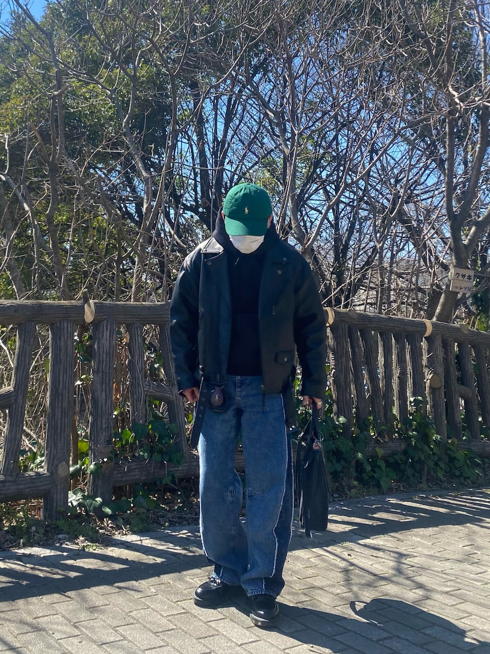 ブラック系のライダースジャケット、ブラック系のパーカー、ブルー系のデニムパンツを着用したメンズの春コーディネートの3枚目の写真