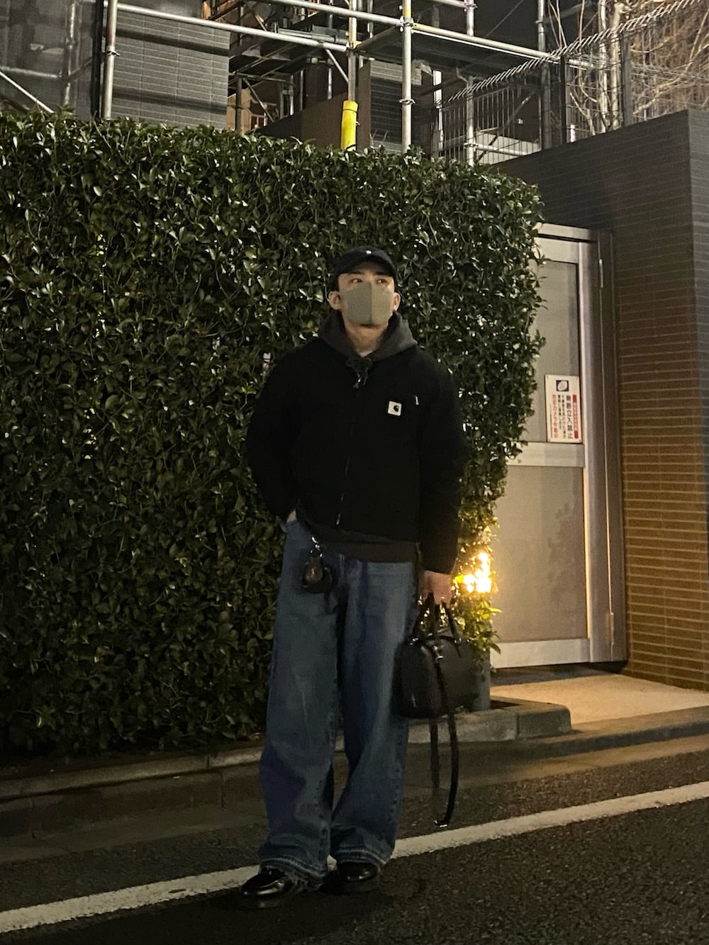 ブラック系のその他アウター、グレー系のパーカー、ブルー系のデニムパンツを着用したメンズの春コーディネートの4枚目の写真