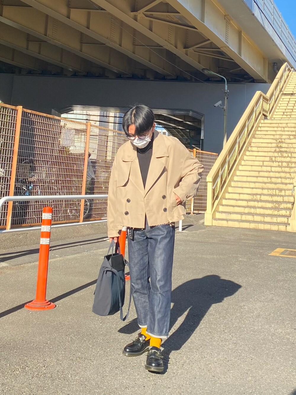 ベージュ系のブルゾン、ブラック系のスウェット、ブルー系のデニムパンツを着用したメンズの冬コーディネートの2枚目の写真