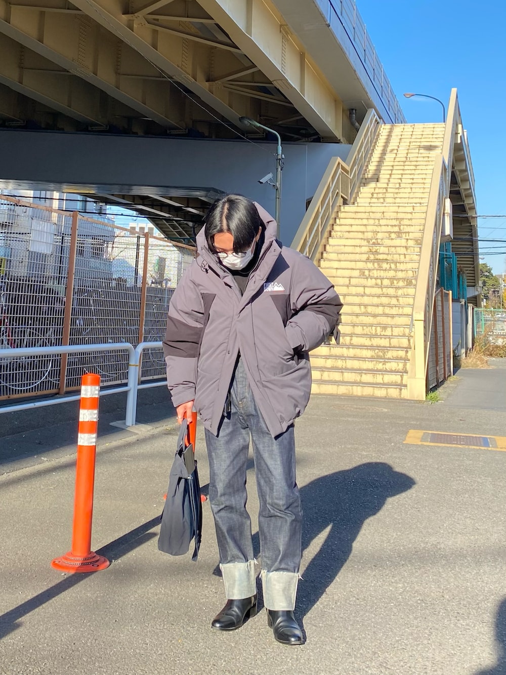 グレー系のダウンジャケット/コート、ブラック系のスウェット、ブルー系のデニムパンツを着用したメンズの冬コーディネートの2枚目の写真