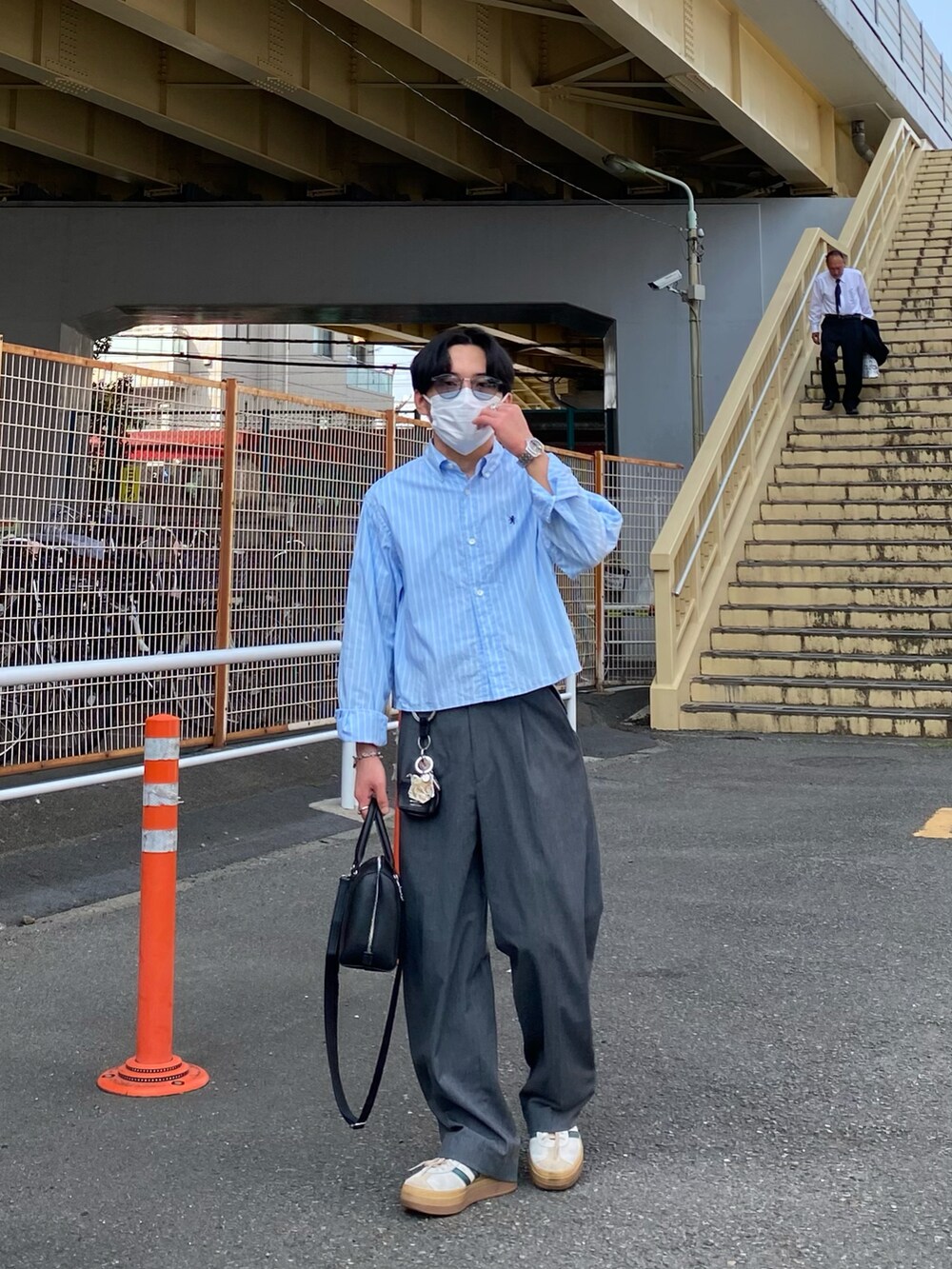 ブルー系のシャツ/ブラウス、ブラック系のボストンバッグ、グレー系のパンツを着用したメンズの春コーディネートの3枚目の写真