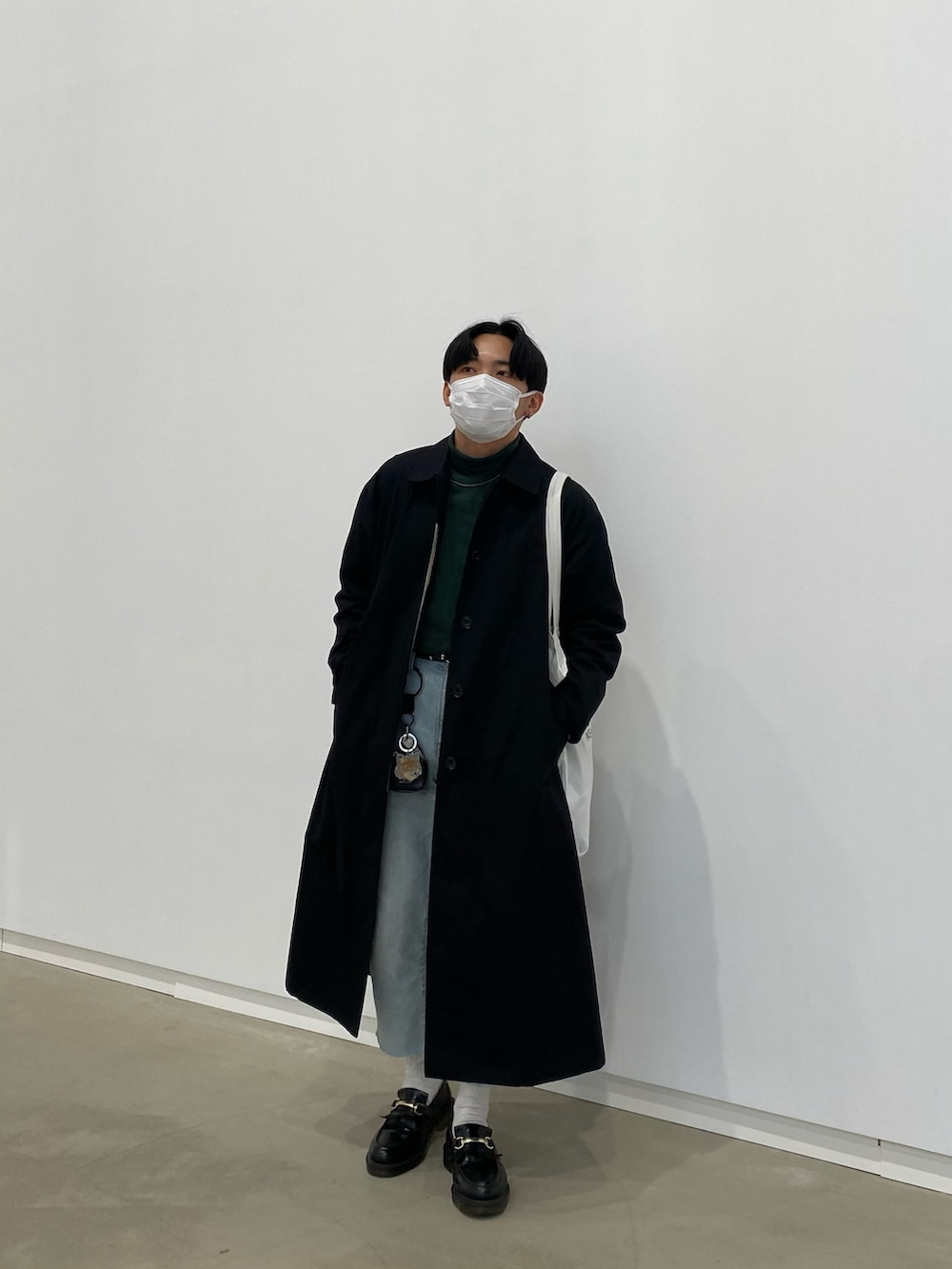 ブラック系のステンカラーコート、グリーン系のスウェット、ホワイト系のトートバッグを着用したメンズの春コーディネートの4枚目の写真
