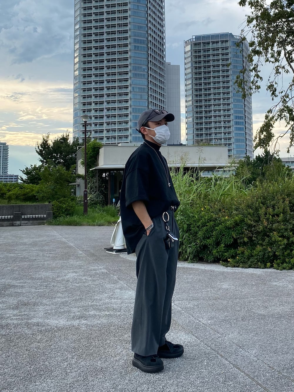 ブラック系のTシャツ/カットソー、グレー系のパンツ、ブラック系のスニーカーを着用したメンズの夏コーディネートの2枚目の写真