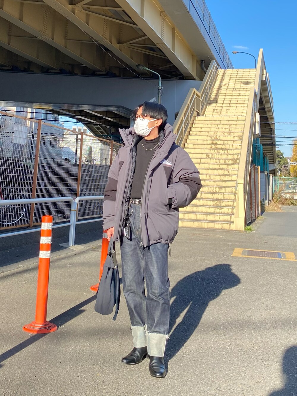 グレー系のダウンジャケット/コート、ブラック系のスウェット、ブルー系のデニムパンツを着用したメンズの冬コーディネートの3枚目の写真